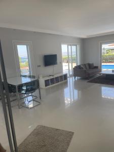 a white living room with a couch and a television at Luxury Villa with amazing view, Cesme in Çeşme