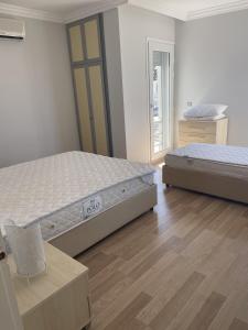 two beds in a room with wooden floors at Luxury Villa with amazing view, Cesme in Cesme