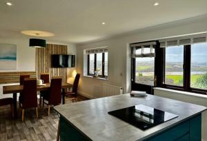 a living room with a table and a dining room at Valley Lodge House - Porth Newquay in Newquay