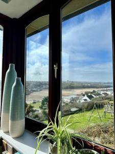 two vases sitting on a window sill with a view at Valley Lodge House - Porth Newquay in Newquay