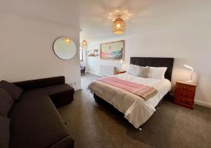 ein Schlafzimmer mit einem Bett und einem Sofa in der Unterkunft Valley Lodge House - Porth Newquay in Newquay