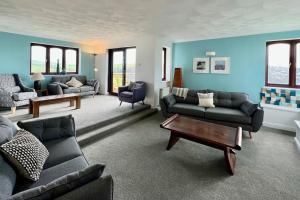 a living room with couches and a coffee table at Valley Lodge House - Porth Newquay in Newquay