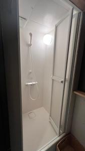 a shower with a glass door in a bathroom at Mojiko Guesthouse PORTO in Kitakyushu