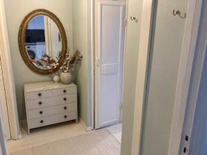 a hallway with a mirror and a dresser with a dresser at Spacious (44 sqm) bohemian studio in trendy Kallio in Helsinki