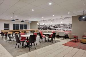 a restaurant with tables and chairs and a bar at Ramada by Wyndham Whitehall/Allentown in Allentown