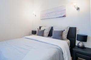 a bedroom with a white bed with blue pillows at JEAN MEDECIN - Modern and brand new 1Br flat in Nice