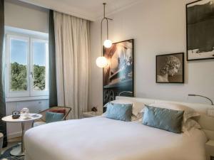 a bedroom with a large white bed and a table at Sofitel Roma Villa Borghese in Rome
