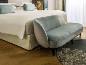 a bedroom with a large bed and a chair at Sofitel Roma Villa Borghese in Rome
