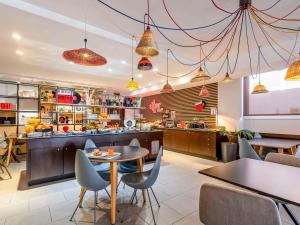 a restaurant with a table and chairs and a kitchen at Ibis Madrid Calle Alcalá in Madrid