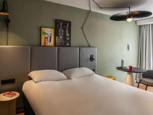 a bedroom with a white bed and a table and a chair at ibis Cannes Centre in Cannes