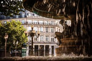 a building with a fountain in front of a building at Hôtel du Louvre, in The Unbound Collection by Hyatt in Paris