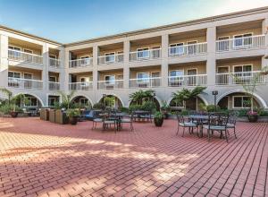 a courtyard with tables and chairs in front of a building at La Quinta by Wyndham San Francisco Airport West in Millbrae