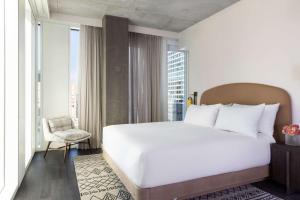 a bedroom with a large white bed and a chair at Hyatt Centric Congress Avenue Austin in Austin