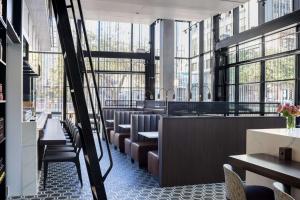 a restaurant with chairs and tables and large windows at Hyatt Centric Congress Avenue Austin in Austin