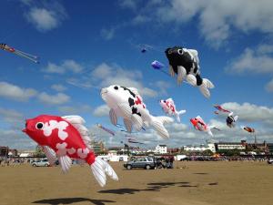 a bunch of kites flying in the sky on a beach at EsJays at Knowles House in Lytham St Annes