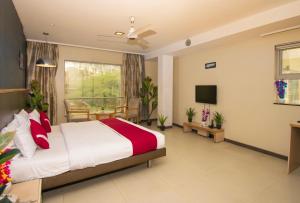 a hotel room with a bed and a television at Octave Koregaon Park in Pune