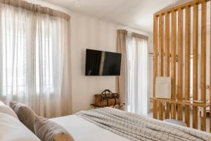 a bedroom with two beds and a flat screen tv at Theseus Seafront House in Sami