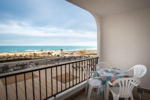 d'un balcon avec une table et des chaises et une vue sur la plage. dans l'établissement Spondylus Apartment, à Empuriabrava