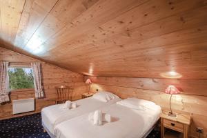 1 Schlafzimmer mit 2 Betten in einer Holzhütte in der Unterkunft Résidence Clos des Etoiles in Chamonix-Mont-Blanc