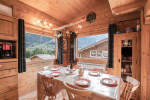 ein Esszimmer mit einem Tisch und einem großen Fenster in der Unterkunft Résidence Clos des Etoiles in Chamonix-Mont-Blanc