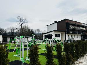 un parque infantil en un parque frente a un edificio en WRZOS resort & wellness en Węgierska Górka