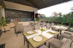 a restaurant with tables and chairs and a balcony at Octave Koregaon Park in Pune