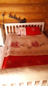 a white bed with red and white blankets and pillows at Apartement Unten im Dorf in Weifenbach