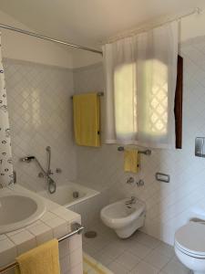 a bathroom with a sink and a tub and a toilet at Costa Smeralda appartamento Pevero Golf in Arzachena