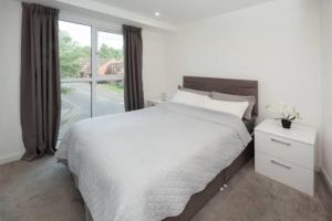 um quarto com uma cama grande e uma janela em A beautiful brand new flat 25-minute to London em Luton