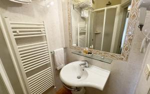a white bathroom with a sink and a mirror at Hotel San Michele in Cortona