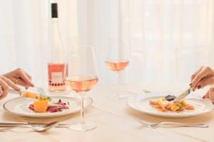 a table with two plates of food and glasses of wine at Hotel Exel in Amstetten