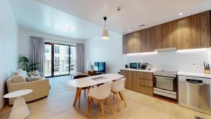 Il comprend une cuisine et un salon avec une table et des chaises. dans l'établissement LC22 - Elegant 1BR with beach access in La Cote Building, à Dubaï