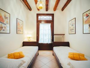 two beds in a room with a window at Ca' Mazzega in Murano