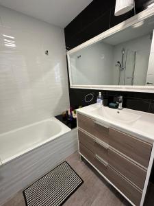 een badkamer met een wit bad, een wastafel en een bad bij Excellent view Julia in Alicante