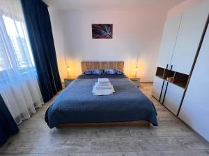 a bedroom with a blue bed with two pillows on it at Agropensiunea Vila Cristina in Niculiţel