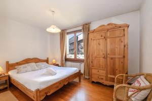 um quarto com uma cama e um armário de madeira em Résidence Alpes 2 em Chamonix-Mont-Blanc