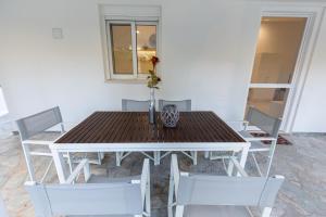 a dining room table with chairs and a vase on it at Katerlove Beach House in Faliraki