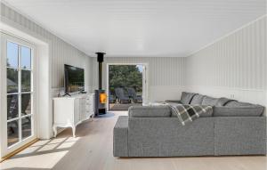 ein Wohnzimmer mit einem Sofa und einem TV in der Unterkunft Cozy Home In Aakirkeby With Kitchen in Vester Sømarken