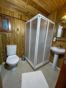 a bathroom with a shower and a toilet and a sink at Tree Houses Hotel in Fethiye