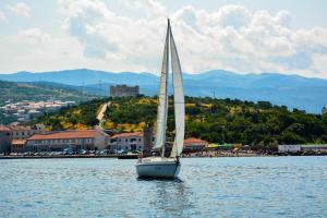 a sailboat in the water in front of a town at Hotel Art in Senj