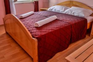 a wooden bed with two pillows on top of it at Hotel Art in Senj