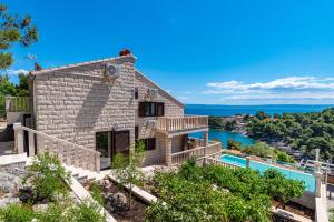 a stone house with a pool and a view at Villa Kadena - Luxury Seaside Villa with Private Heated Pool in Selca