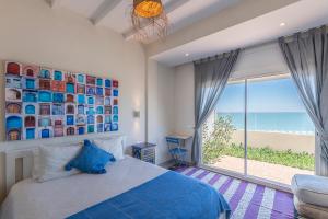 - une chambre avec un lit et une vue sur l'océan dans l'établissement Kite House Dakhla, à Dakhla