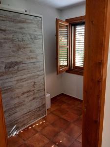 baño con ducha y suelo de baldosa. en Apartamento rural Muga, en Sant Llorenç de la Muga