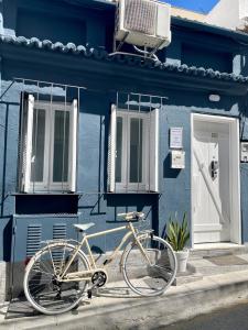 una bicicleta estacionada frente a un edificio azul en OIKIASTUDIOS2 en Patras