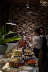 a woman standing in front of a buffet of food at Hotel Areca in Legazpi