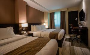 Cette chambre comprend deux lits et un bureau. dans l'établissement Hotel Areca, à Legazpi