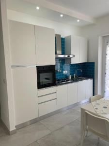 a kitchen with white cabinets and a stove top oven at Approdo Felice in Formia