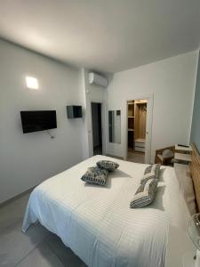 una camera da letto con un letto bianco con due cuscini sopra di Approdo Felice a Formia