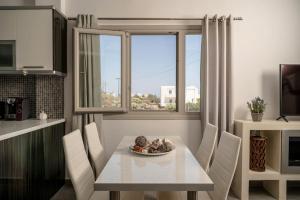 a dining room with a table and chairs and a window at In the heart of Fira & free pool - Nychteri suite in Fira